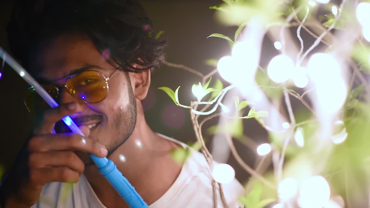 젊은 행복한 아시아 게이 남성은 파티 축하 행사에서 화려한 조명으로 즐깁니다.