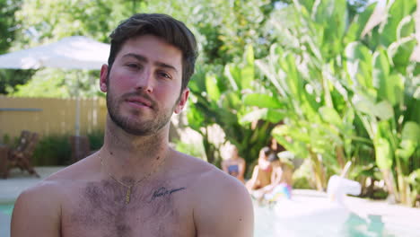 Portrait-Of-Bare-Chested-Man-Outdoors-With-Friends-Enjoying-Summer-Pool-Party