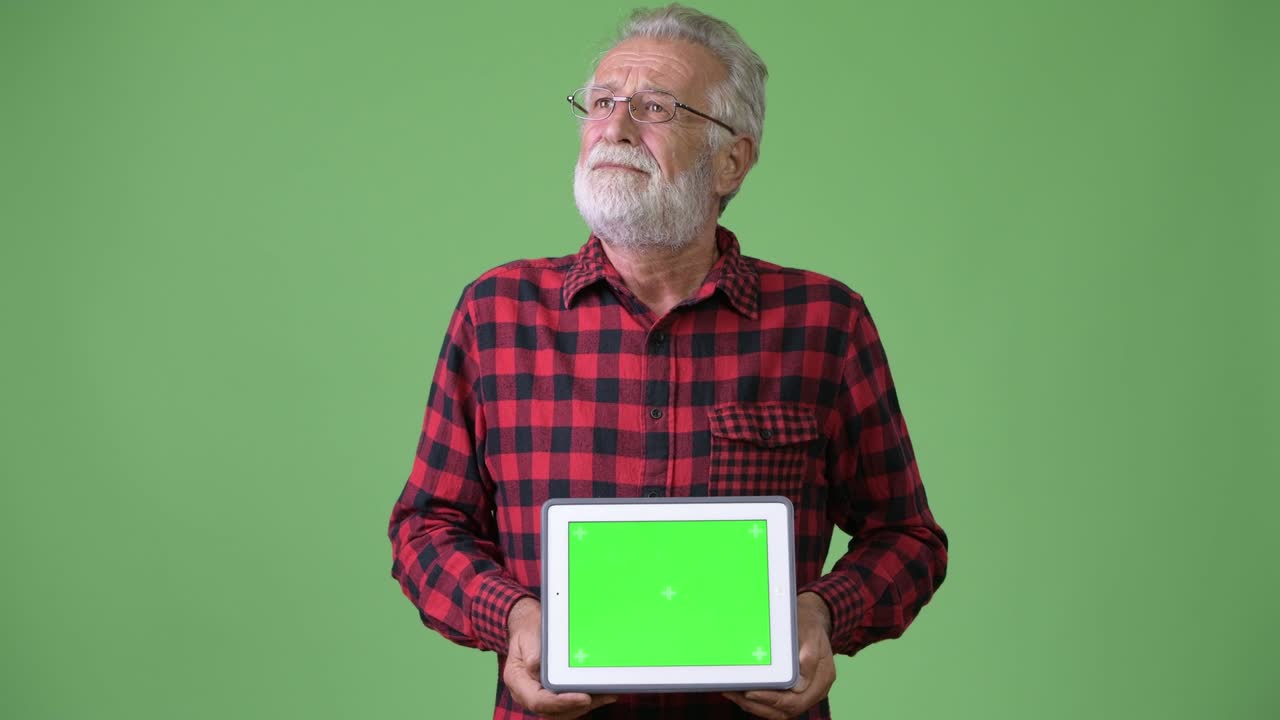 hombre de barba viejo y guapo contra un fondo verde.