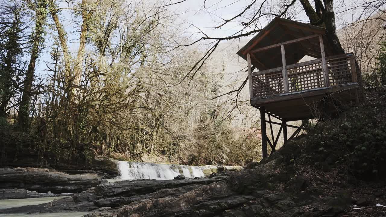 cubierta de observación en un bosque con río en el día soleado de otoño