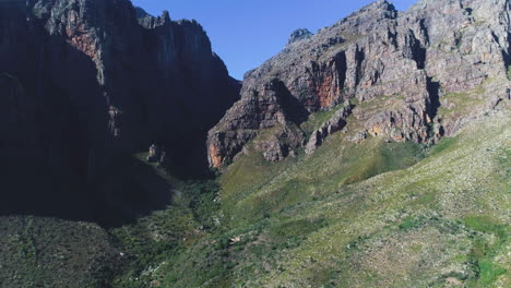 aerial - flying towards rugged, imposing sandstone mountains
