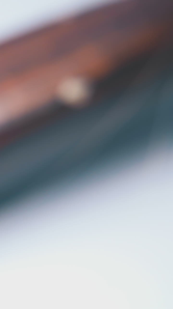 motion past oval hairbrush covered with hair and wooden handle on grey background extreme close view