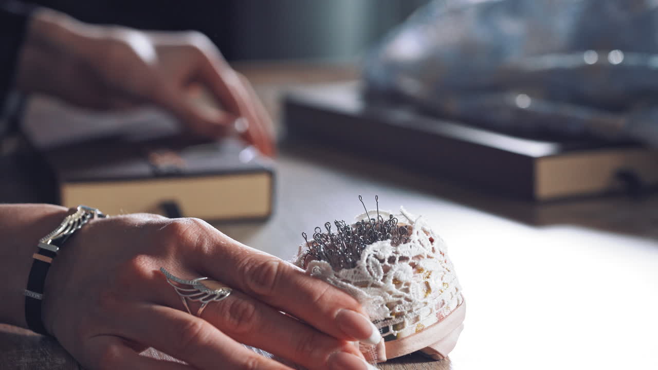 Pins for sewing in special stand. Tailor with pin from cushion in sewing factory