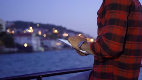 man using tablet at sea. working.