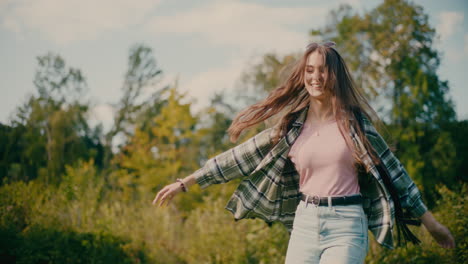 zorgeloze jonge vrouw die plezier heeft in het bos.