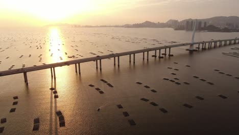 Tráfico-En-El-Puente-De-La-Bahía-De-Hong-Kong-shenzhen-Al-Atardecer,-Con-Piscinas-De-Cultivo-De-Peces-Y-Ostras,-Vista-Aérea