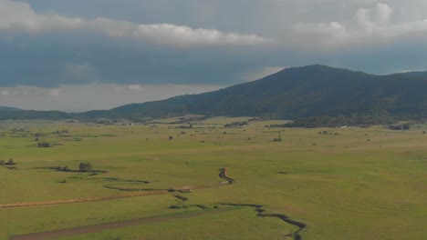 fertile fields and rolling panoramic hills surrounding lika-senj county, croatia, aerial reveal