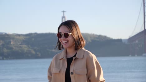 happy and smiling thai tourist in front of landmark statue cristo rei in lisbon