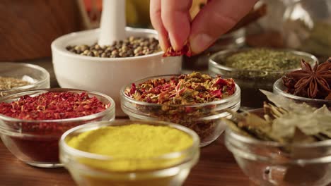 colourful spices in glass bowls close-up. middle eastern and arabian culture. seasoning and flavors. pepper, coriander, cinnamon, turmeric, paprika, cumin. different kinds of dry herbs for cooking.