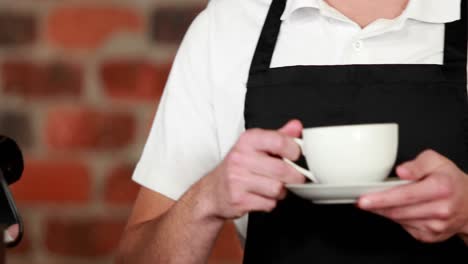 smiling barista handing a cup of coffee