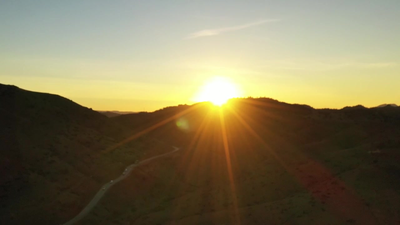 Aerial drone sunset above rugged mountain passes and winding roads illuminated by warm golden light in the Middle Atlas Morocco ideal for travel inspirational and documentary projects