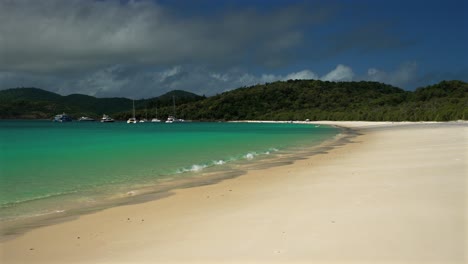 whitehaven beach whitsundays island sailboats sunny clouds aerial drone airlie national park australia aus qld outer great barrier reef clear blue turquoise ocean shore holiday vacation static shot
