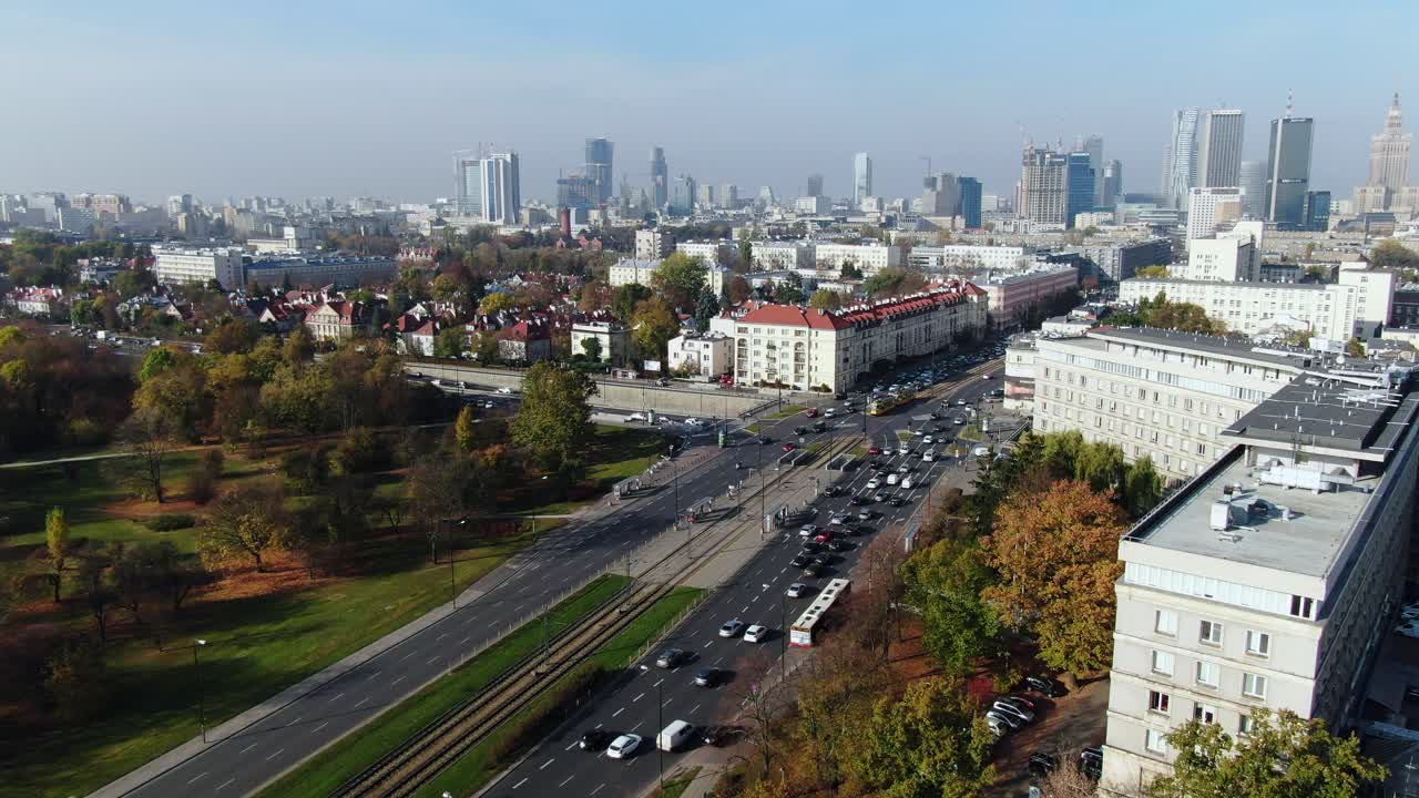 Grande cruzamento rodoviário perto do centro de Varsóvia, arquitetura moderna em contraste com edifícios da Cidade Velha, trânsito intenso.