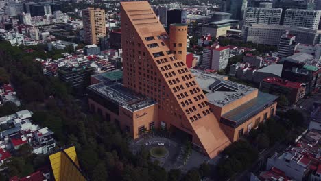 track out drone shot of el palacio de hierro triangular shape store in polanco, mexico city in a cloudy sunday