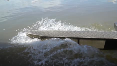 close up view of metal canoe outrigger moving through water, slow motion