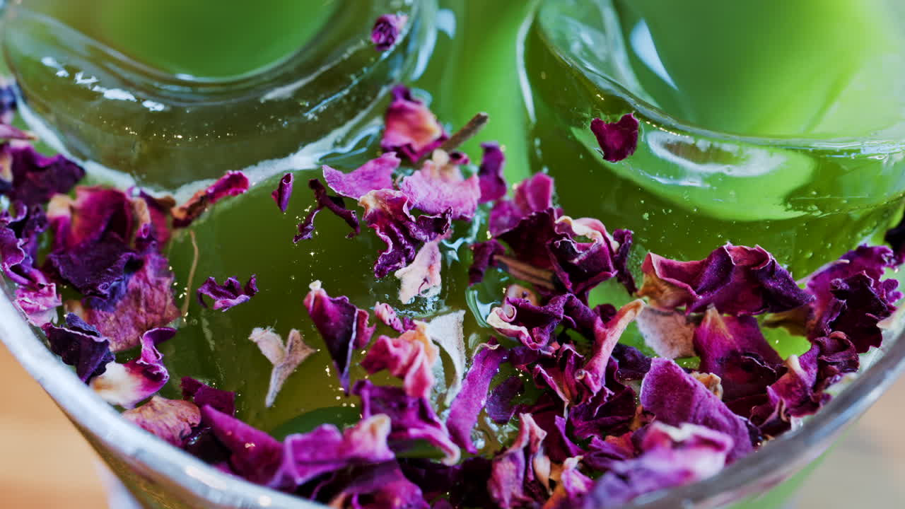Close up of an iced matcha in a glass with purple dried flowers on top