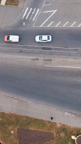 aerial drone view of road in city with moving cars. intersection of roads with transport. vertical video