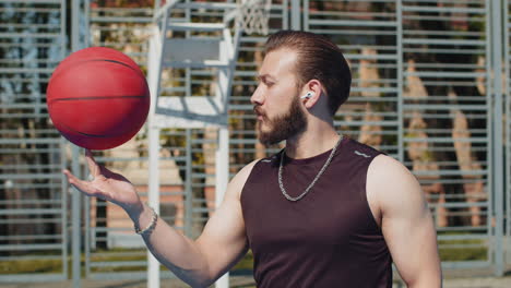 concentrated athletic man in sportswear playing basketball game trying to spin ball on his finger