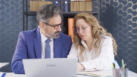 businessman and businesswoman working on laptop.