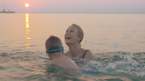 mother teaching little son to swim