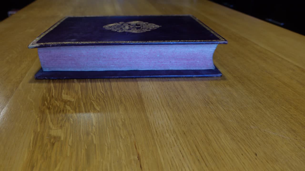 Man's hands open and leafing through an old book in the library