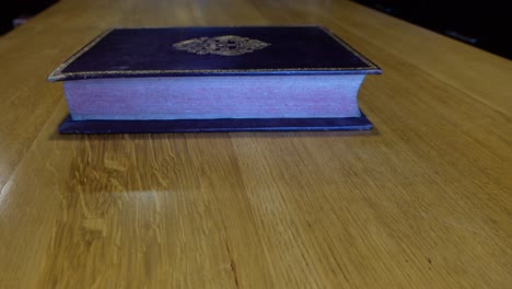 man's hands open and leafing through an old book in the library