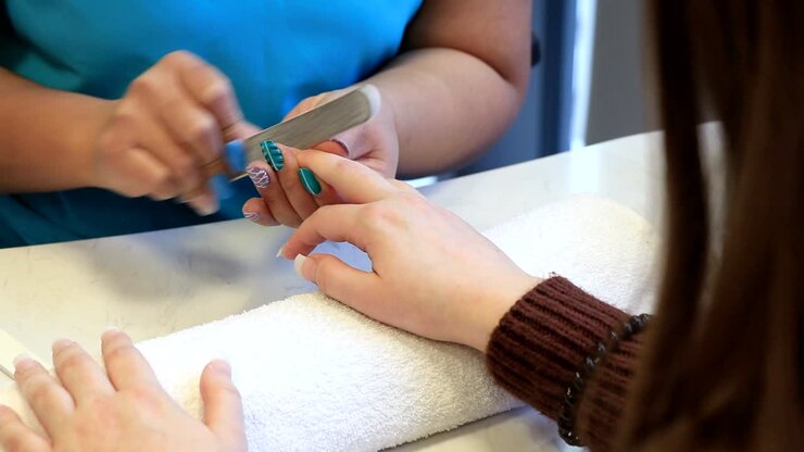 A girl has a fingernails treatment in a beauty salon