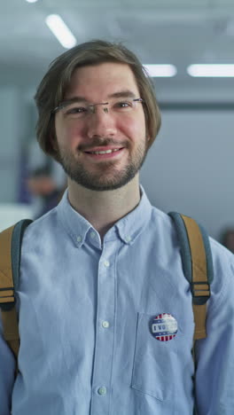 portrait of businessman, united states of america elections voter. mature man stands in a modern polling station, poses and looks at camera, smiles. background with voting booths. civic duty concept.