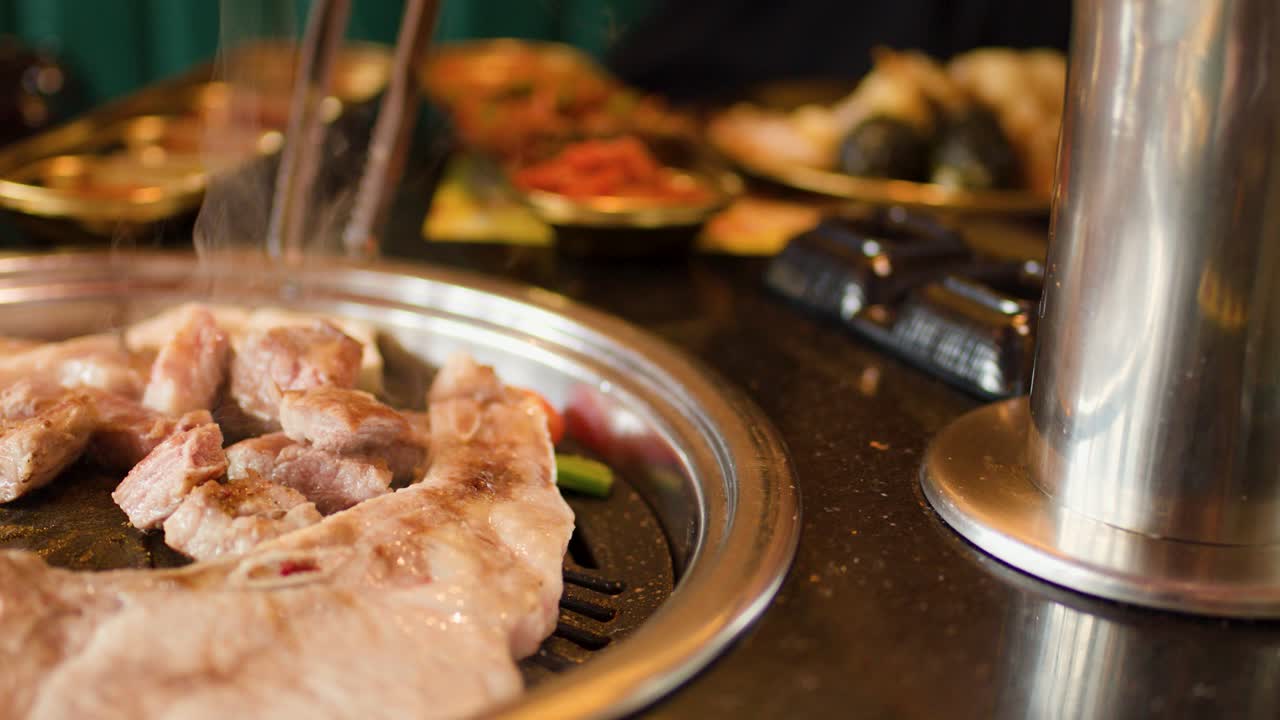 Pork belly grilled and cut with scissors, mushrooms added, warm lighting, close-up, restaurant setting
