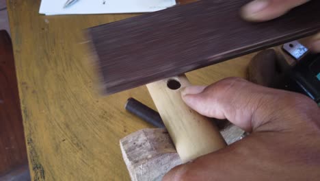 Handwerker-Schleift-Eine-Traditionelle-Bambusflöte,-Hände-Nahaufnahme-Eines-Musikinstruments-Aus-Indonesien,-Handgefertigt,-Südostasien