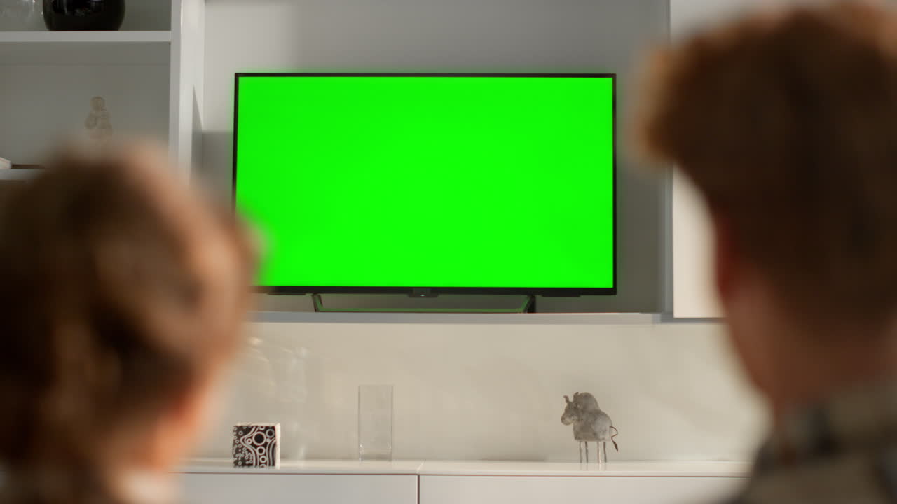 Film streaming green screen tv in living room. Friends talking resting at home.