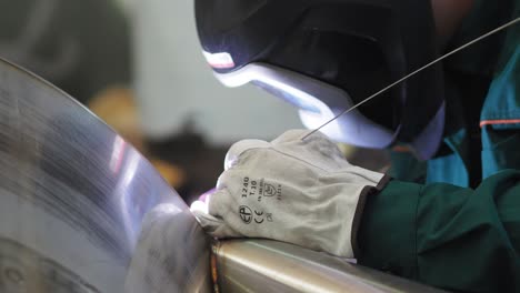 welder, using vig, tig, mig mag method to welding stainless steel parts, close up. the welder uses a mask to protect your eyes. argon welding of stainless steel sheet, parts. scene l.