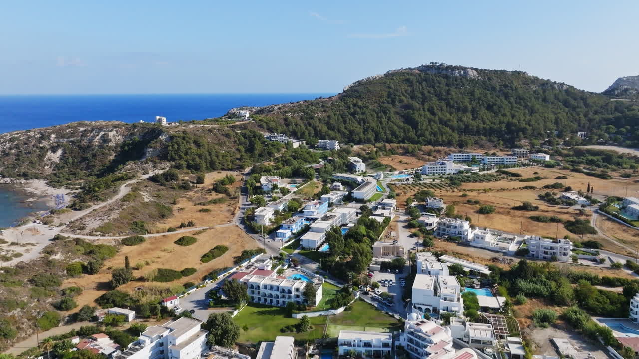 Aerial view tilting over the townscape of Faliraki, sunny day in Rhodes, Greece