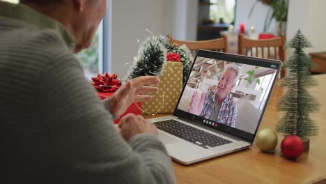 Caucasian-senior-man-on-video-call-with-senior-male-friend-at-christmas-time