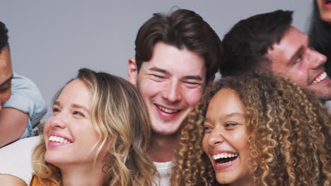 group studio shot of young multi-cultural friends smiling and laughing at camera in slow motion