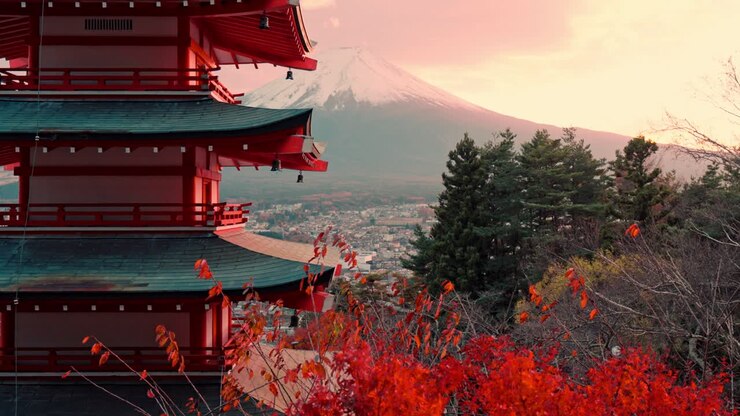 Una vista affascinante della Pagoda Chureito circondata da un vivido fogliame rosso al culmine dell'autunno, con il Monte Fuji che si erge imponente sullo sfondo.