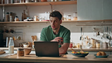 thoughtful worker holding cup looking away kitchen counter closeup. man thinking