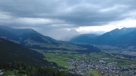 dramatic weather builds over the tyrolean alps near axams, captured with a cinematic drone view of moody skies and lush green valleys