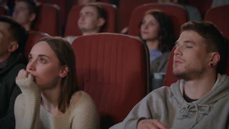 man embracing woman in cinema theater. romantic date concept