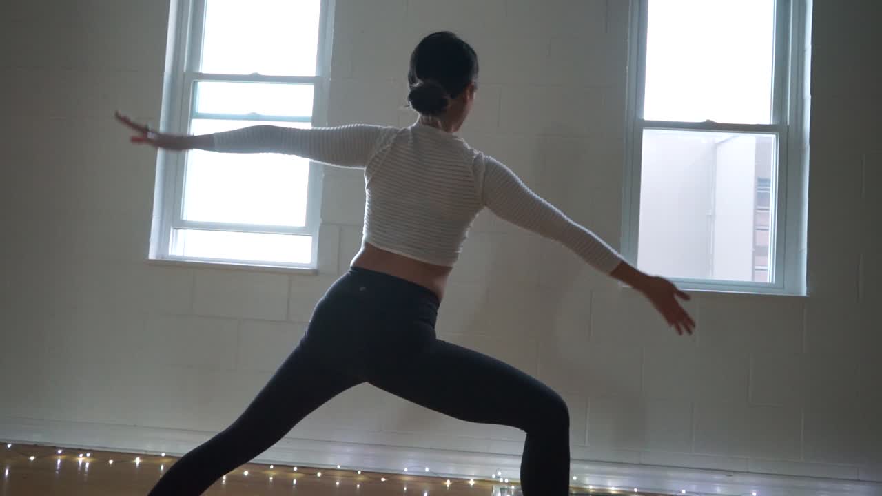 profesora de yoga en estudio con poca luz