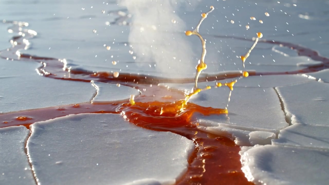 Flydende rød-orange væske danner kanal på revnet bleg plade, stød skaber damp og dråber