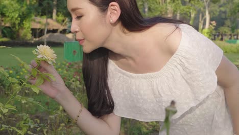 beautiful young woman smelling a rose flower