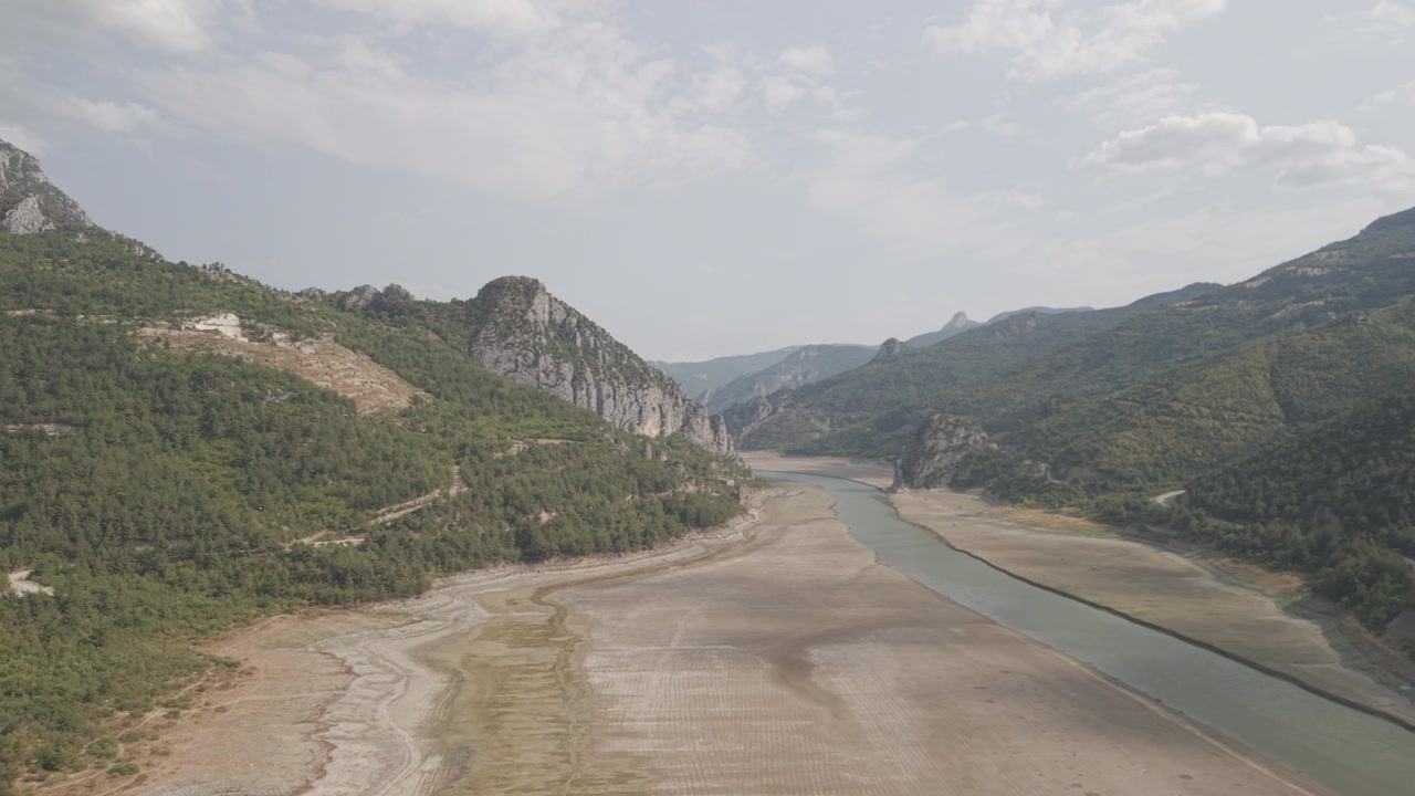 4K 10-bit drone shot flying forward low over a green river inside the giant rocky walls of Sahinkaya Canyon on a sunny day in Samsun, Turkey