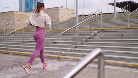 woman running up stadium stairs