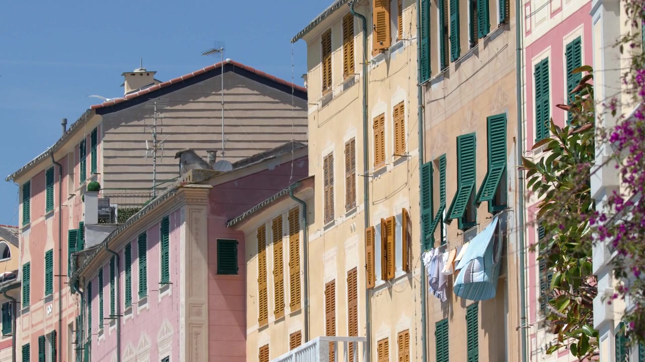 Inquadratura statica di facciate mediterranee tradizionali con bucato steso ad asciugare sotto la luminosa luce solare estiva