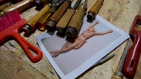 italian sculptor in his workshop working on a olive wood statue