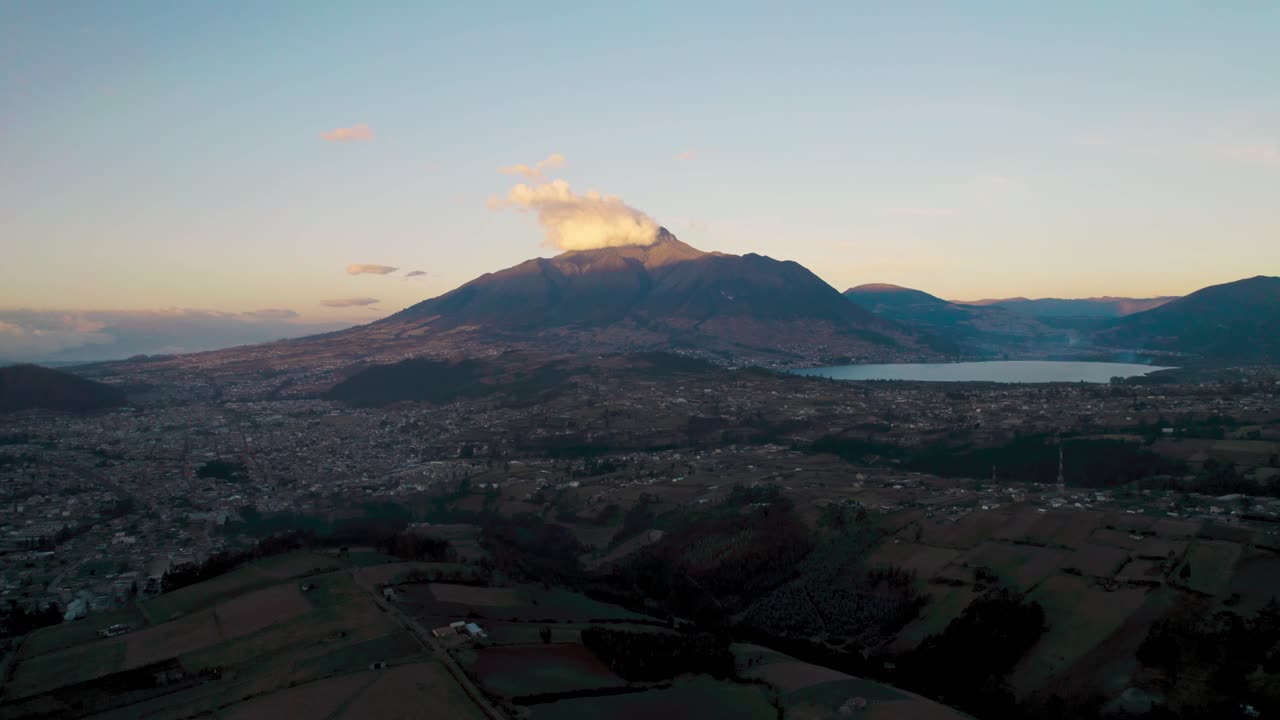 Splendida ripresa aerea di Otavalo, Ecuador, con il maestoso vulcano Imbabura sormontato da nuvole e la città che si estende nella valle