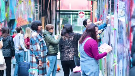 people painting graffiti on melbourne's iconic street