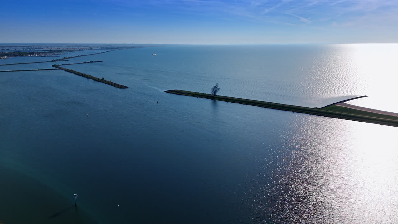 Waterscape of the Merkemeer Lake with the dams. Figure of a man sitting on the dike. The Netherlands. Aerial view.