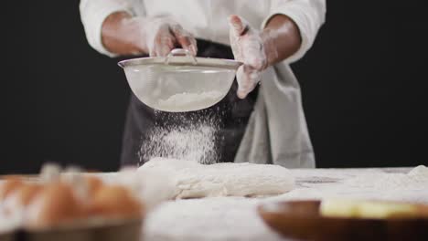 Vídeo-De-Cocinero-Tirando-Harina-Sobre-La-Mesa-Sobre-Fondo-Negro